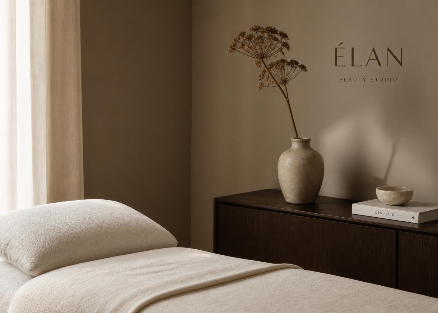 Quiet studio interior with a cream treatment bed and a dried botanical stem
